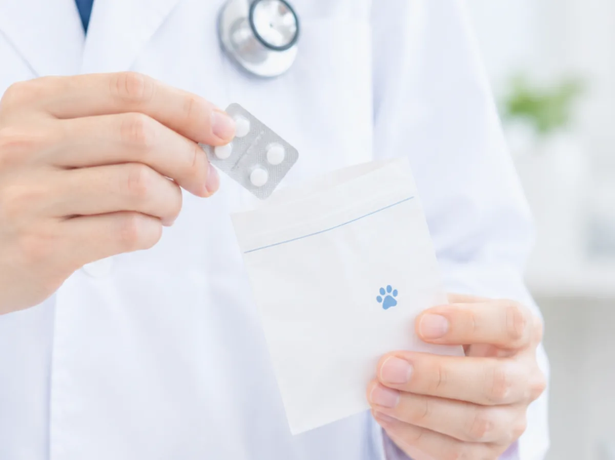 薬剤師が錠剤を薬袋に入れているイメージ